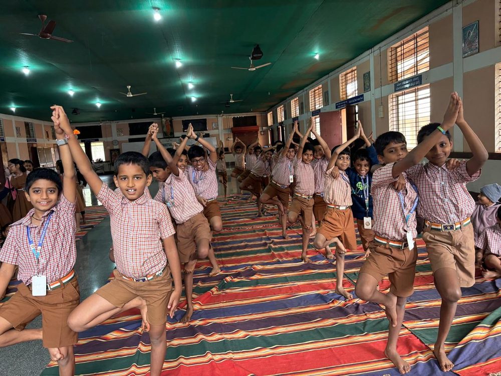 Children standing in tree pose in a row during a yoga session